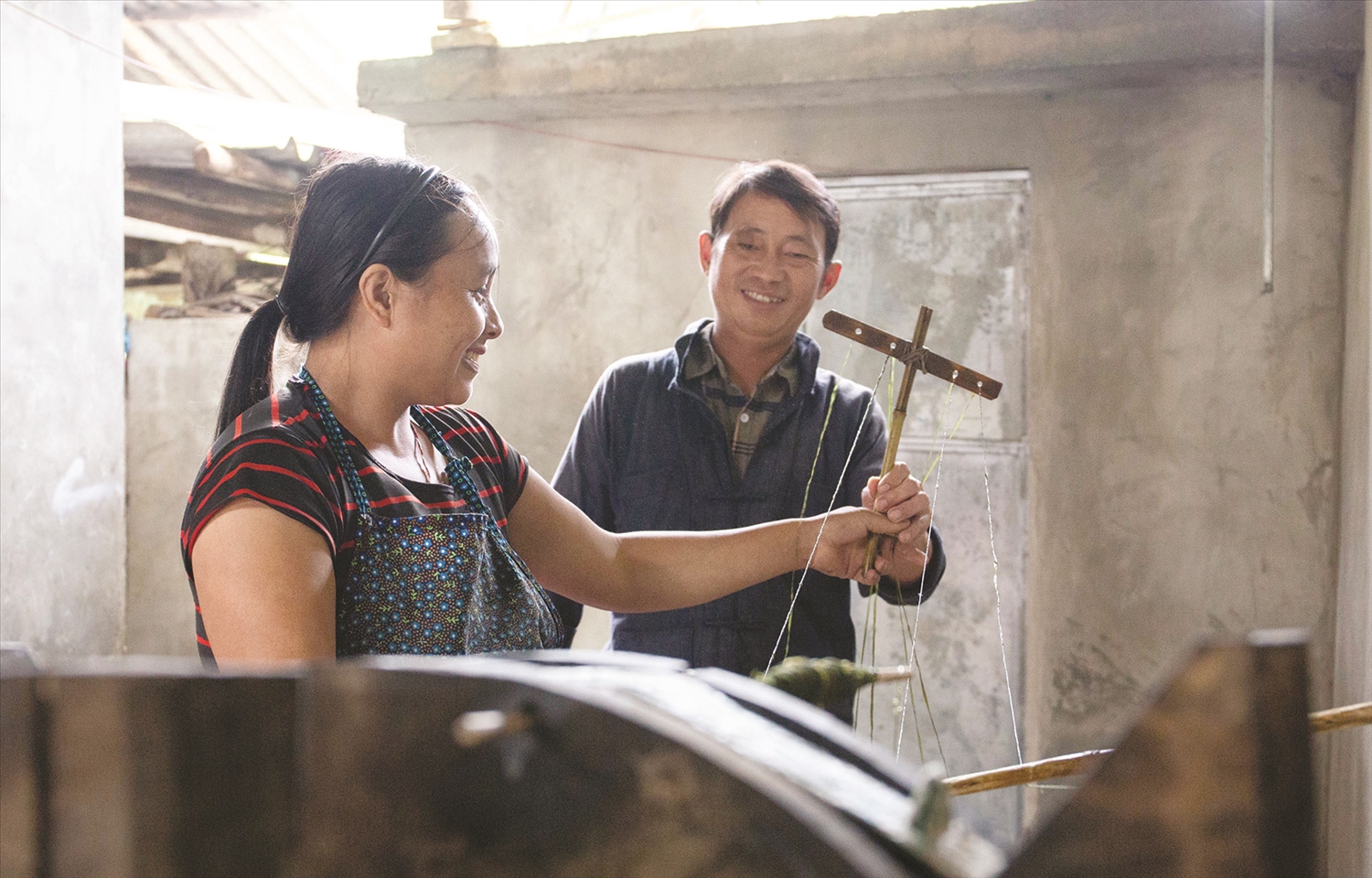 Anh Giàng Mí Cấu phụ giúp vợ se lanh, dệt vải. Anh Giàng Mí Cấu phụ giúp vợ se lanh, dệt vải.