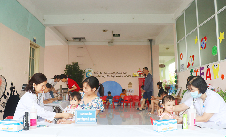 Khám sàng lọc cho trẻ trước khi tiêm tại điểm tiêm Trường Mầm non Liên Mạc.