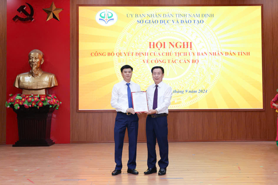 Đồng chí Chủ tịch UBND tỉnh Phạm Đình Nghị trao Quyết định và tặng hoa chúc mừng đồng chí Nguyễn Xuân Hồng, Giám đốc Sở GD&ĐT. Ảnh: Viết Dư