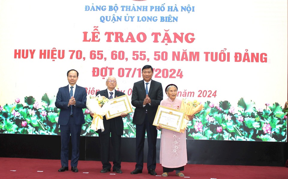 Trưởng ban Dân vận Thành ủy Đỗ Anh Tuấn và lãnh đạo quận Long Biên trao Huy hiệu Đảng tặng các đảng viên lão thành.
