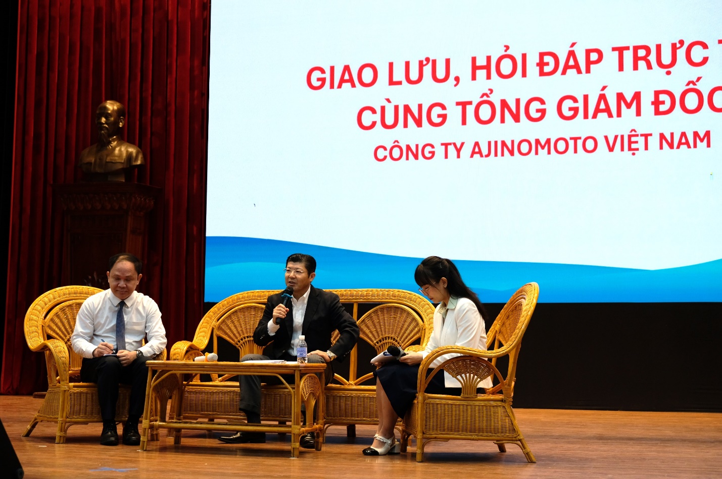 Hơn 800 sinh viên Đại học Bách Khoa Hà Nội giao lưu cùng Tổng Giám đốc Ajinomoto Việt Nam- Ảnh 2. A group of people sitting on a stage Description automatically generated