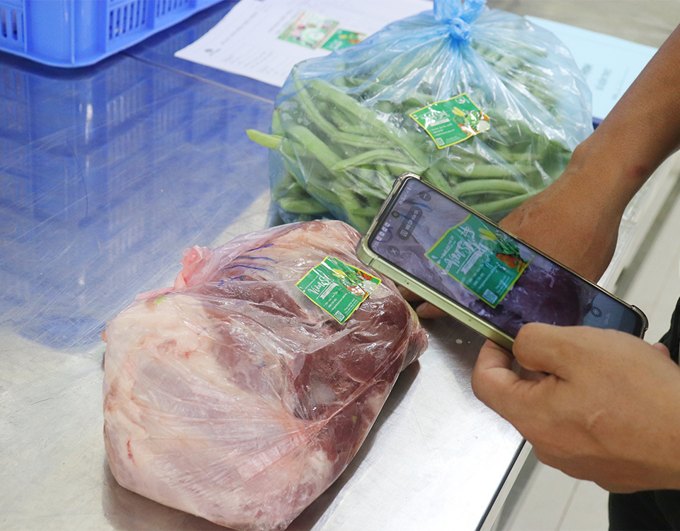 Đại diện cha mẹ học sinh quét mã QR code, truy xuất nguồn gốc thực phẩm tại bếp ăn bán trú Trường THCS Nguyễn Thị Minh Khai.
