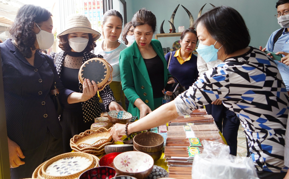Khách du lịch tham quan điểm bán và giới thiệu sản phẩm làng nghề khảm chai Chuyên Mỹ, huyện Phú Xuyên. Ảnh: Công Tâm