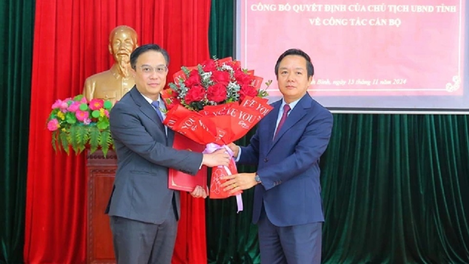 Ông Phạm Quang Ngọc - Chủ tịch UBND tỉnh Ninh Bình (bên phải) trao quyết định và tặng hoa chúc mừng ông Đặng Thái Sơn - tân Giám đốc Sở Kế hoạch và Đầu tư.