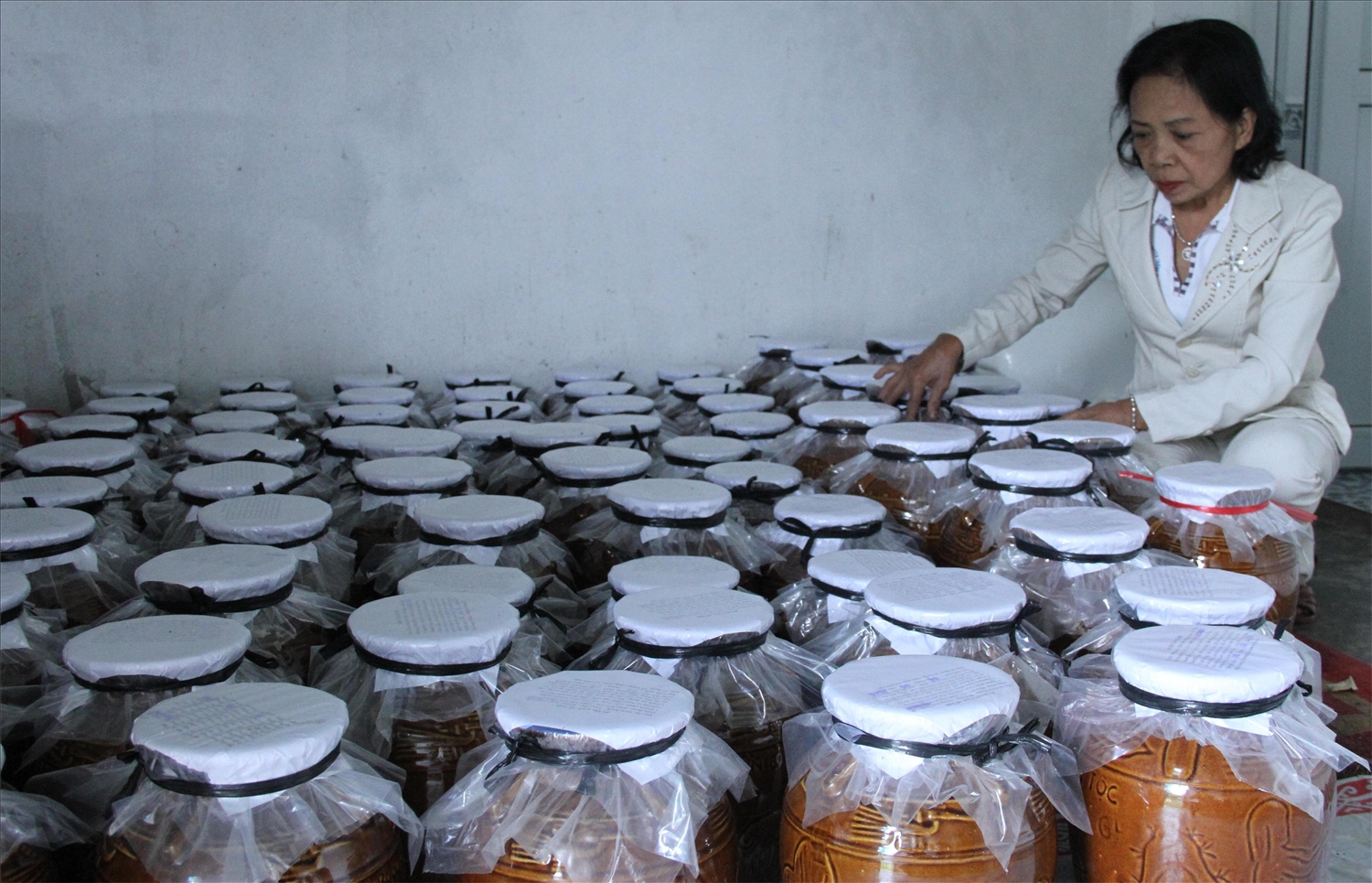 Bà H’Phong Niê kiểm tra những hũ rượu cần Bà H’Phong Niê kiểm tra những hũ rượu cần