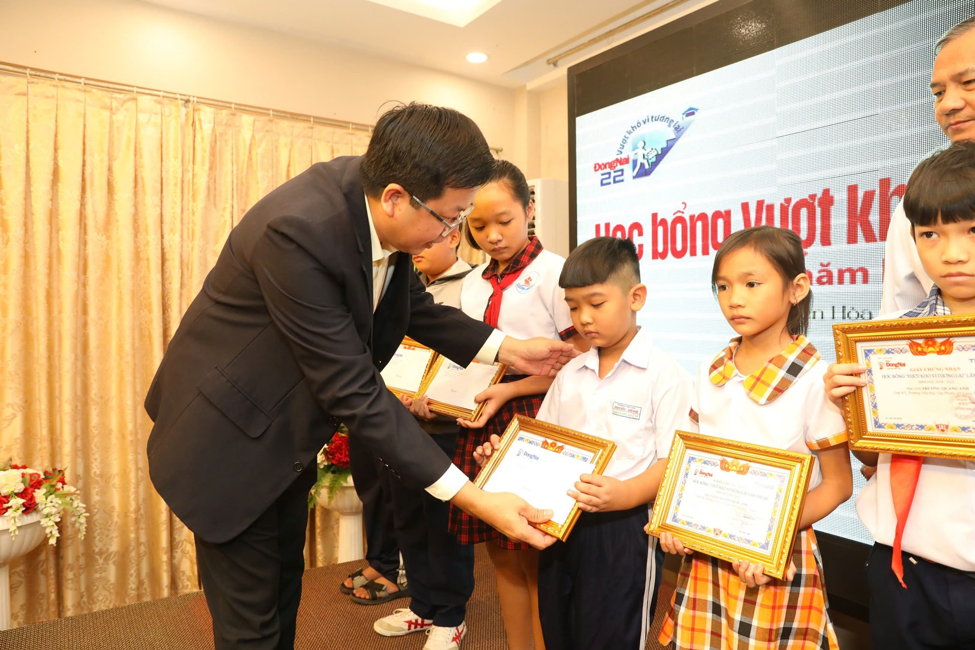 Ông Lê Hữu Có - Phó Giám đốc Ban Văn hóa THACO trao học bổng cho các em 1-1