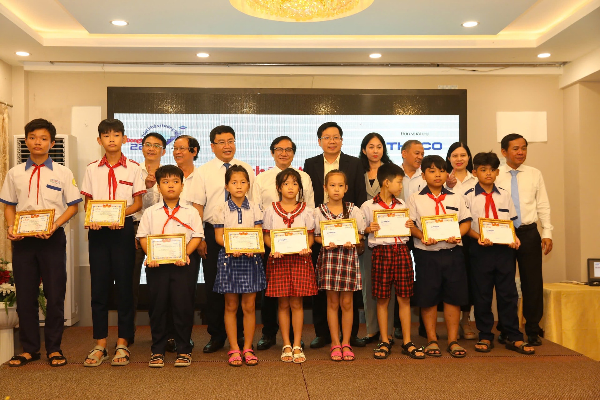 Ông Lê Hữu Có - Phó Giám đốc Ban Văn hóa THACO cùng các Lãnh đạo tỉnh, Lãnh đạo Báo Đồng Nai chụp hình với các em học sinh nhận học bổng 2-1