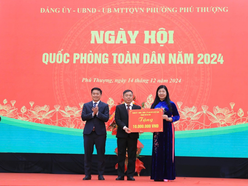 Chủ tịch Ủy ban Mặt trận Tổ quốc Việt Nam TP Hà Nội Nguyễn Lan Hương tặng hoa và trao quà chúc mừng của TP tới cán bộ, Nhân dân phường Phú Thượng