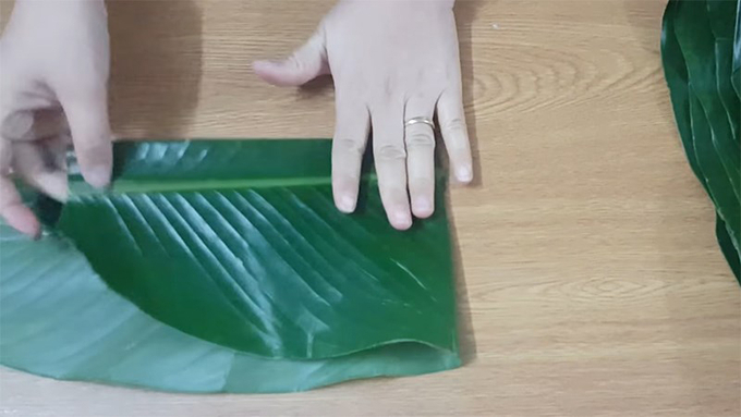 2-224314_224.jpg Sau đó, gấp đôi lá dong lại, dùng tay miết đường gấp nếp.