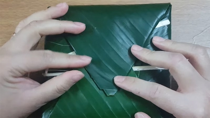 6-224523_367.jpg Tiếp đến gấp 2 bên mép lá còn lại và căn chỉnh để bánh được vuông vắn.