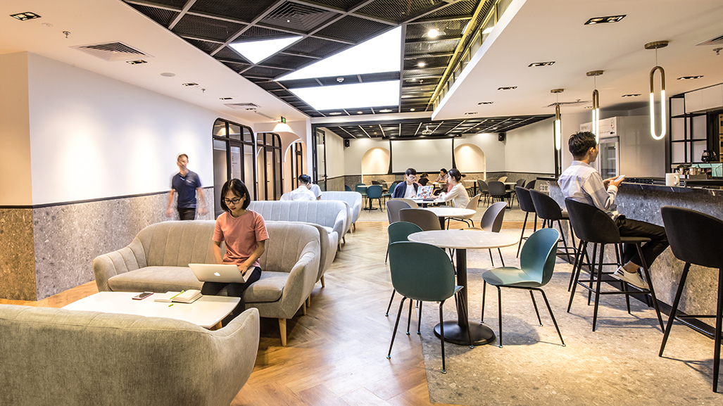 IWG khai trương các địa điểm coworking space mới tại Việt Nam- Ảnh 1. A group of people in a room with tables and chairs Description automatically generated