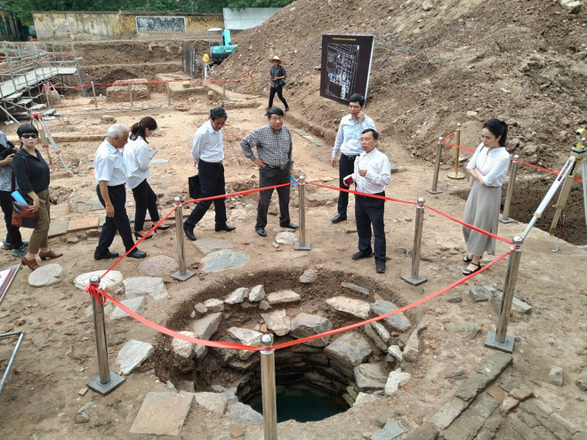 Tiến sỹ Tống Trung Tín, Chủ tịch Hội Khảo cổ Việt Nam, dẫn đoàn chuyên gia khảo sát miệng giếng mới tìm được. (Ảnh: Minh Thu/Vietnam+) Công bố nhiều phát hiện khảo cổ quan trọng ở Hoàng thành Thăng Long ảnh 1